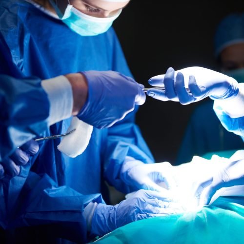 Surgeons passing scissors to each other Surgeons passing scissors to each other